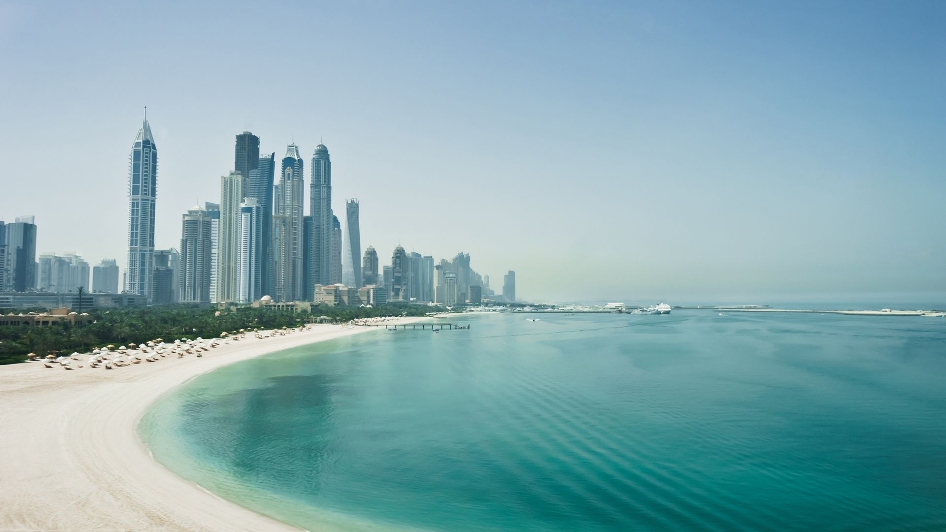 Strand an der Dubai Marina mit Wolkenkratzern und türkisfarbenem Wasser
