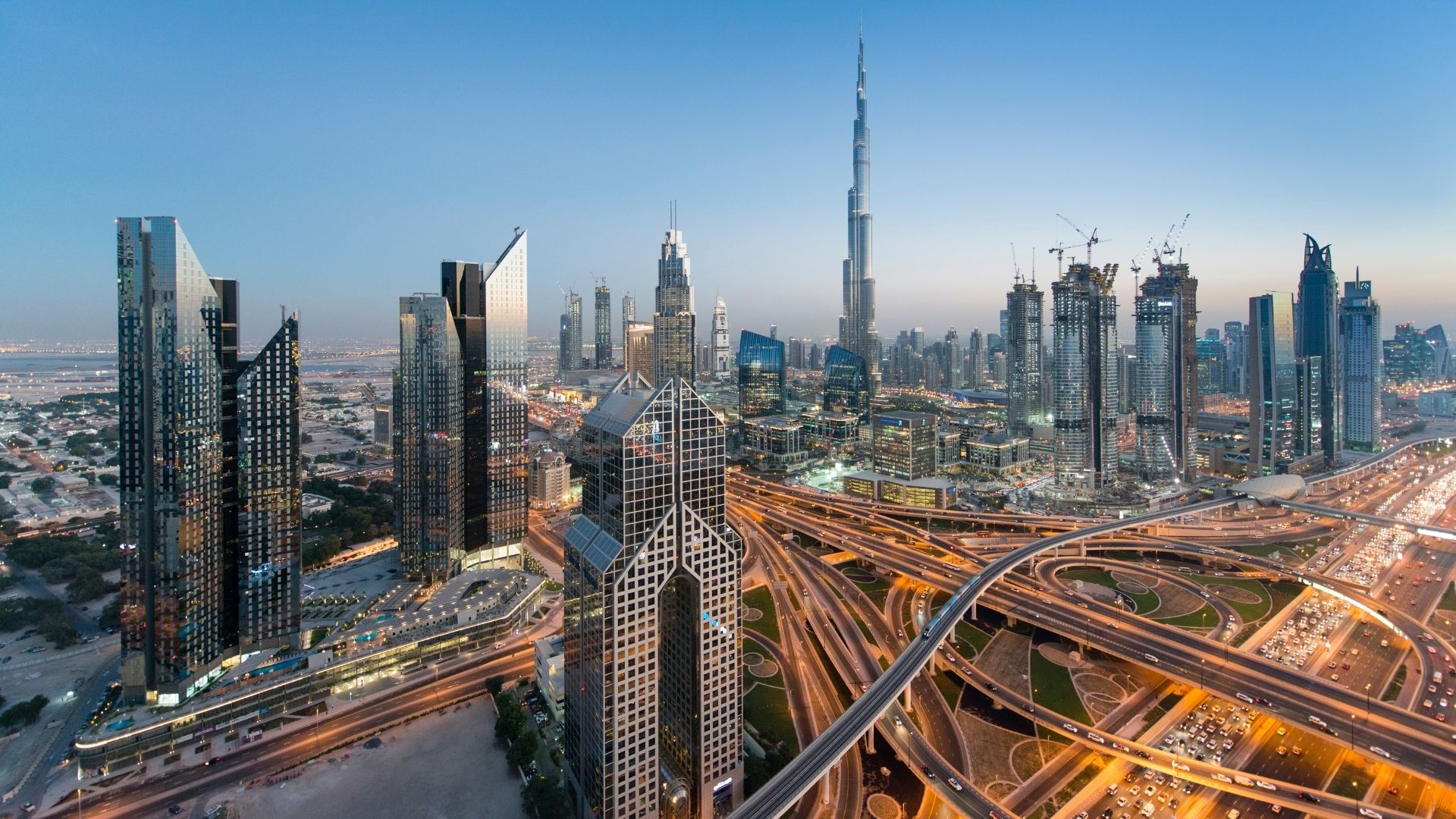 Skyline von Dubai in der Abenddämmerung mit dem Burj Khalifa und beleuchteten Autobahnen