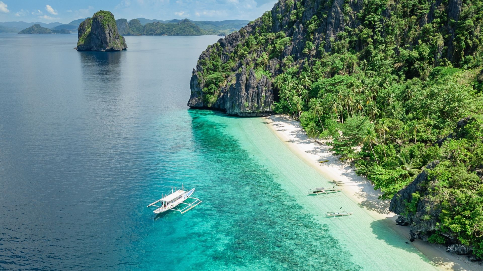 Praia e lagoa turquesa de El Nido em Palawan, nas Filipinas, com um barco bangka