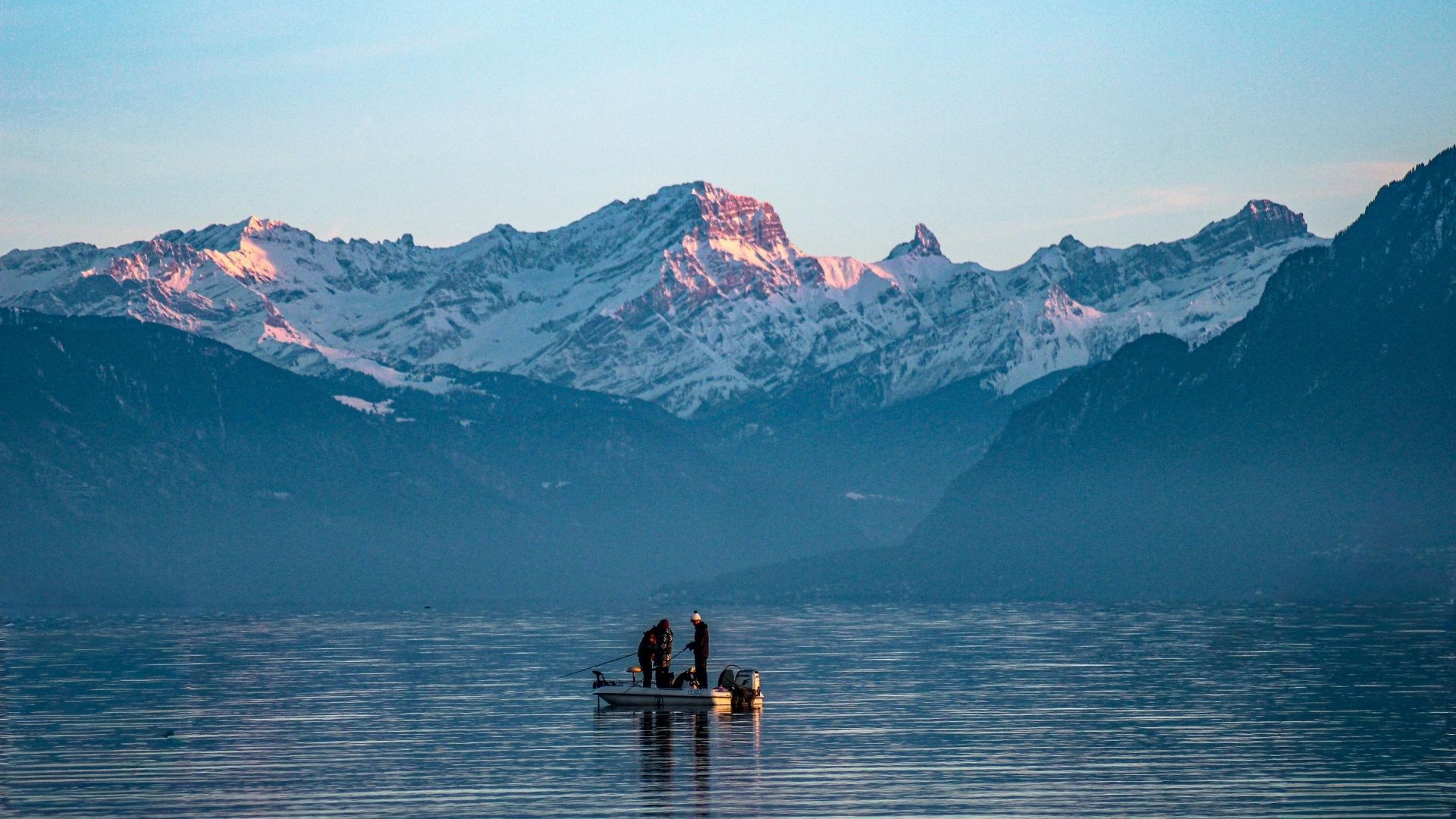 O Lago Léman ao amanhecer com os Alpes suíços nevados ao fundo
