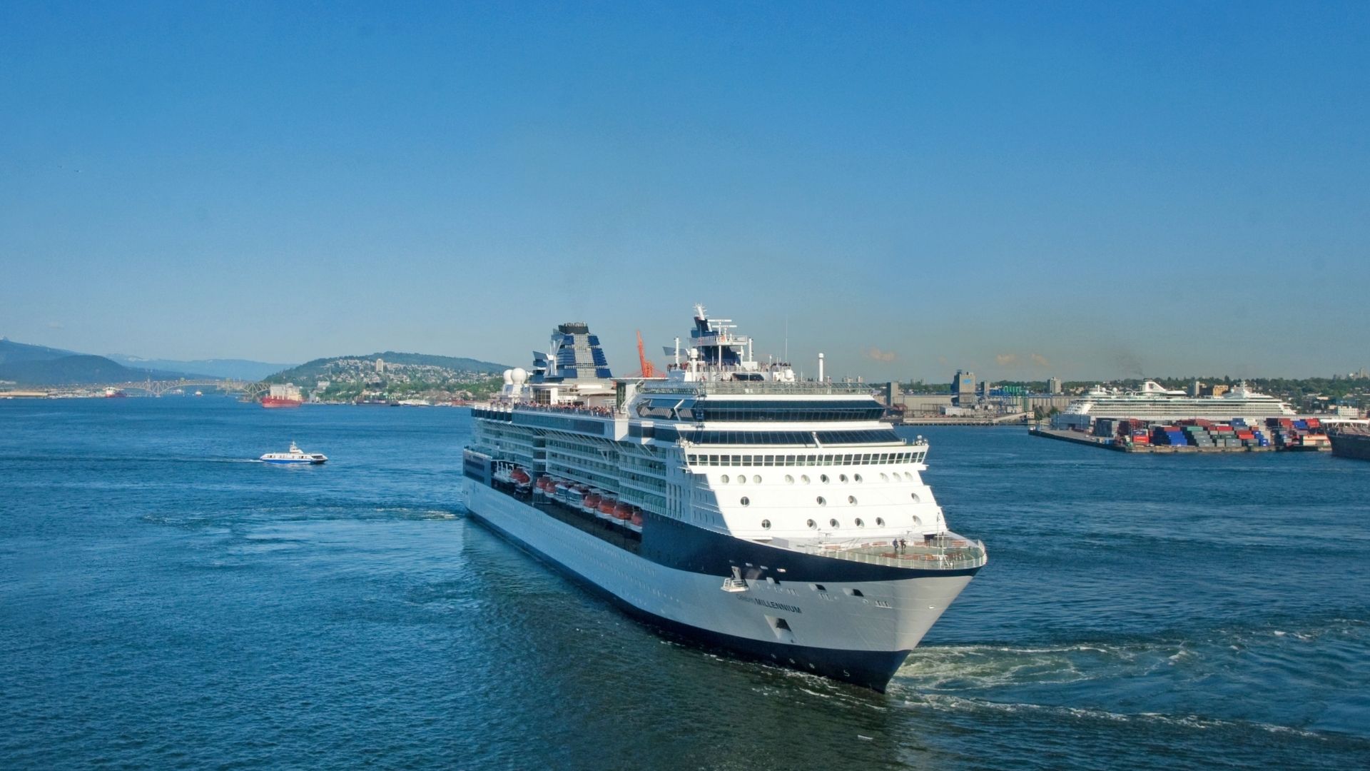 Um grande navio de cruzeiro a sair do porto, com a costa ao fundo