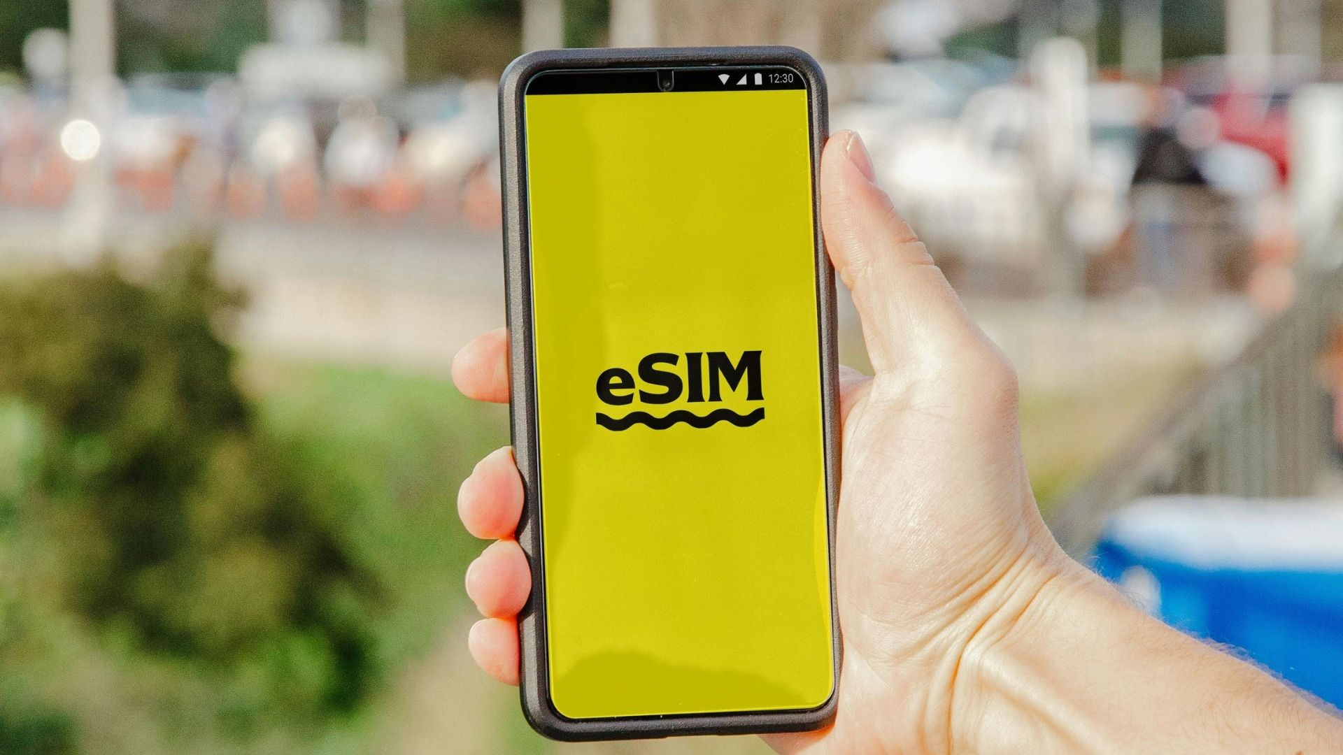 Smartphone mit aktivierter eSIM in der Hand, im Freien