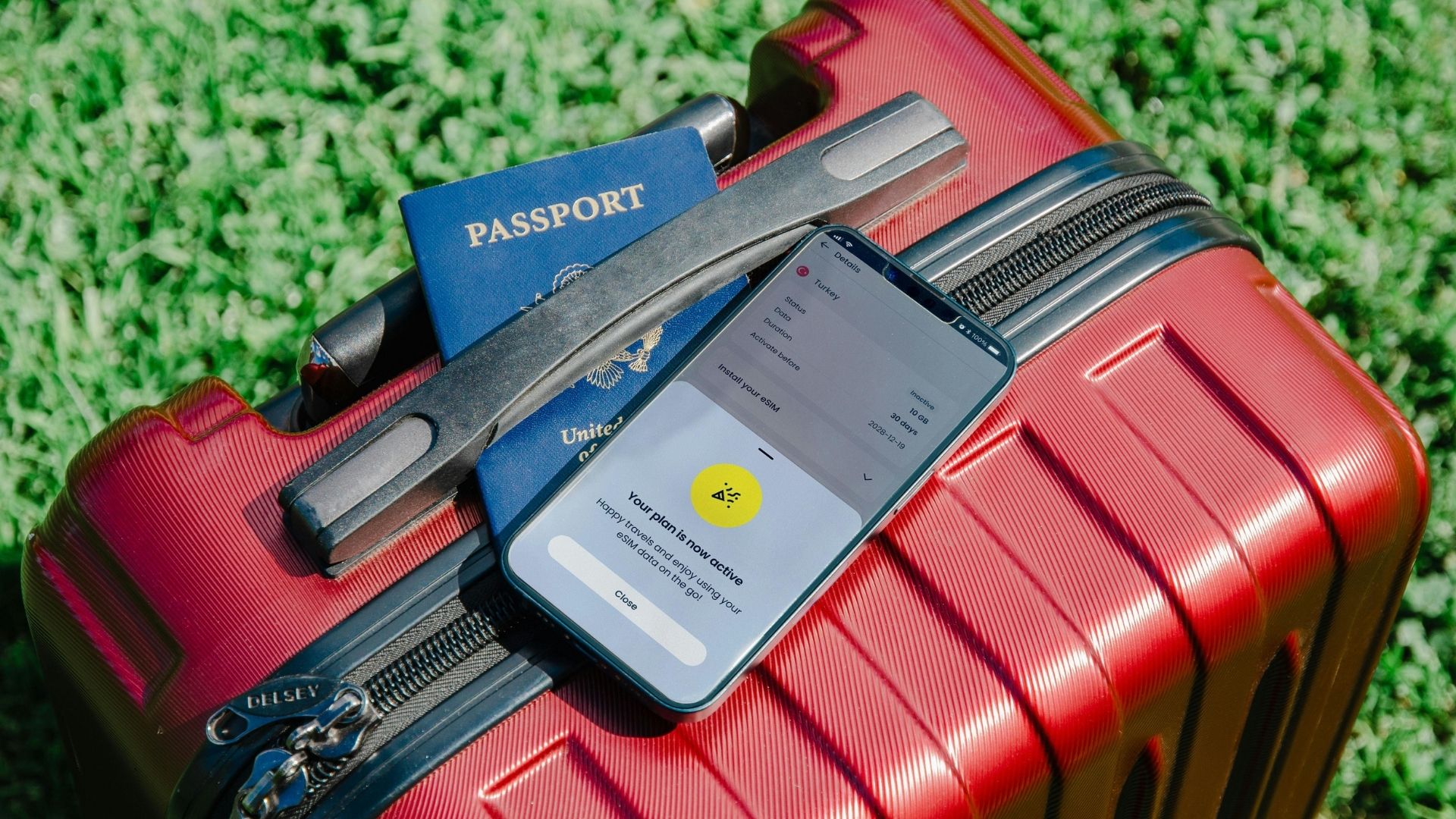 Reisepass und Smartphone auf einem Koffer, bereit für eine Auslandsreise